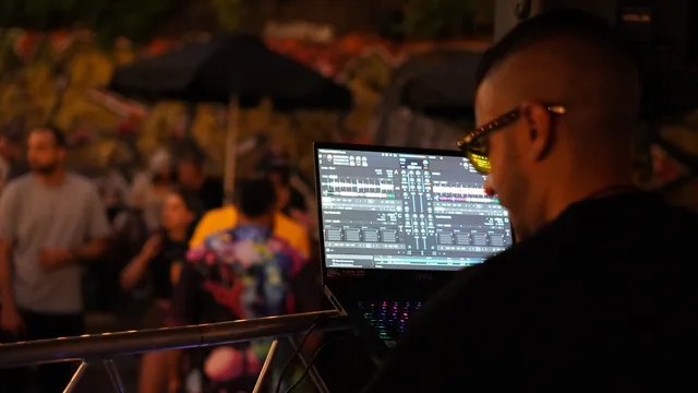 A DJ behind the decks with the Electric Brew crowd in the background